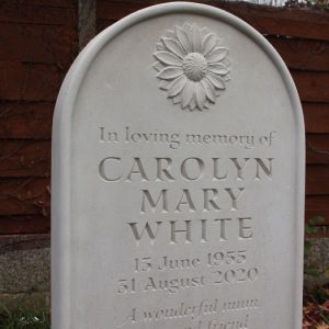white Portland Limestone headstone memorial in graveyard